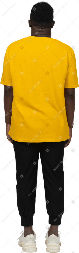 Vista posteriore di un giovane uomo dalla pelle scura in maglietta gialla che sta fermo