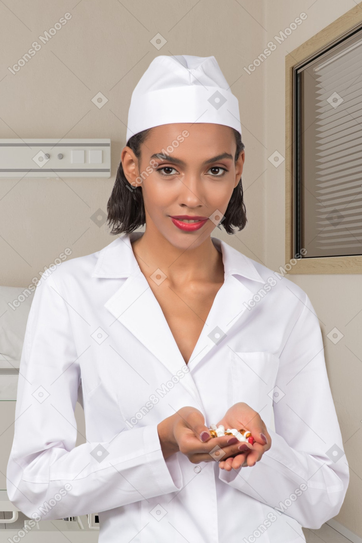 A female nurse holding pills in her hands