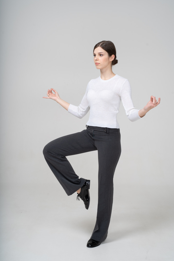 Front view of a young woman in suit doing yoga
