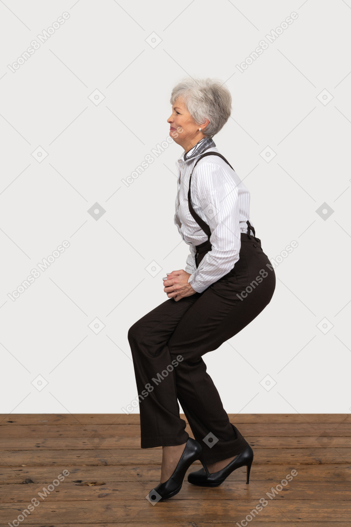 Side view of a woman in office clothes doing half squat
