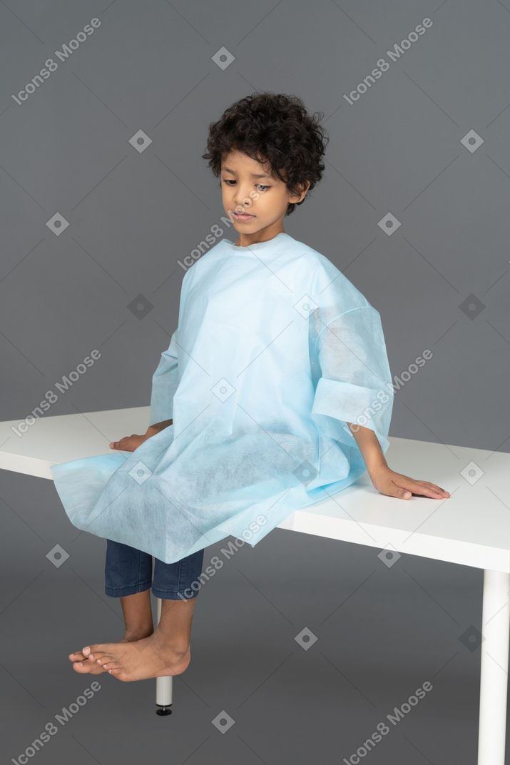 Junge sitzt auf dem tisch