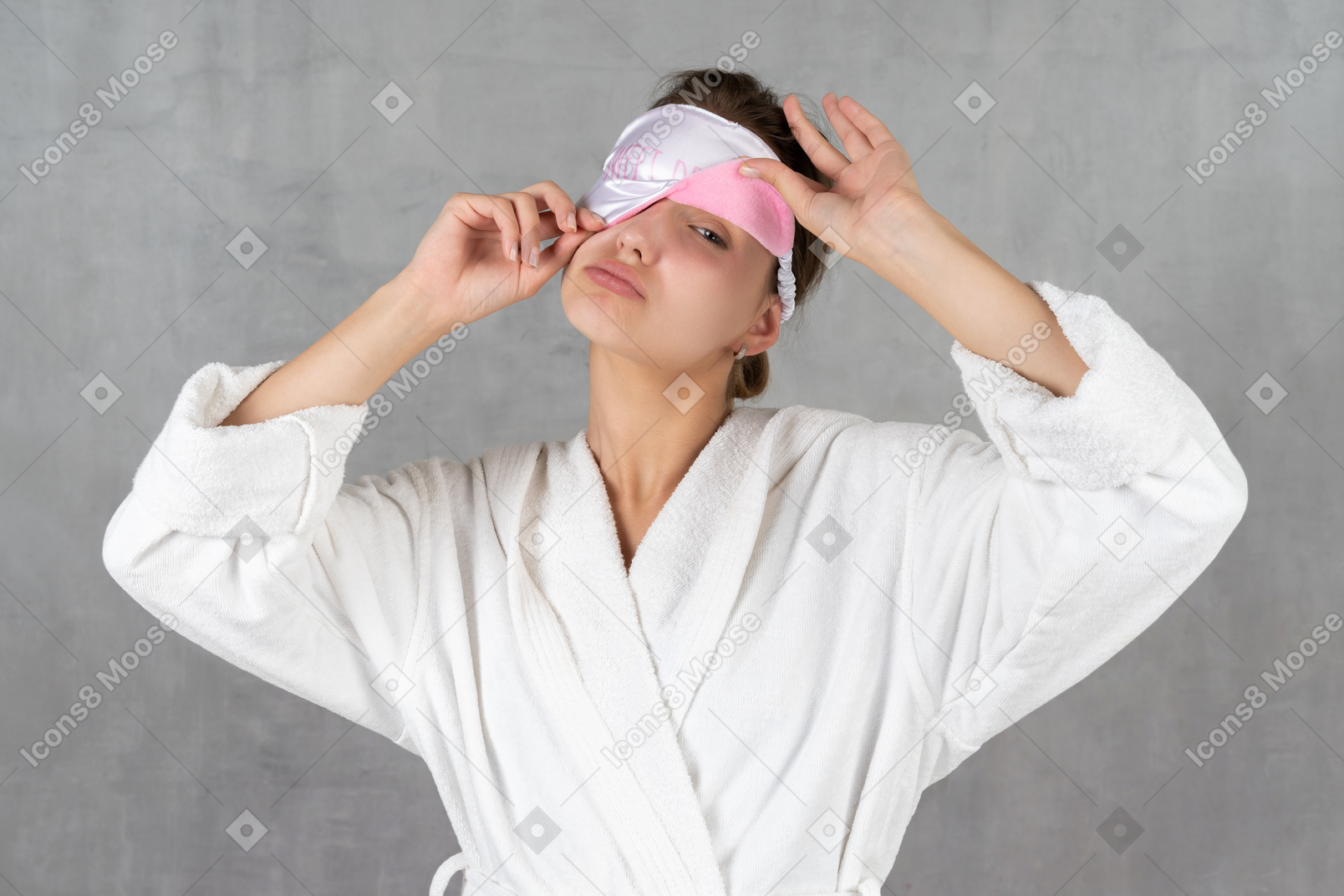 Mulher de roupão com máscara de dormir cobrindo um olho