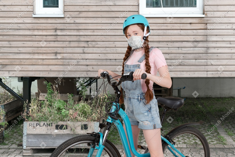 A girl wearing a face mask while riding a bike