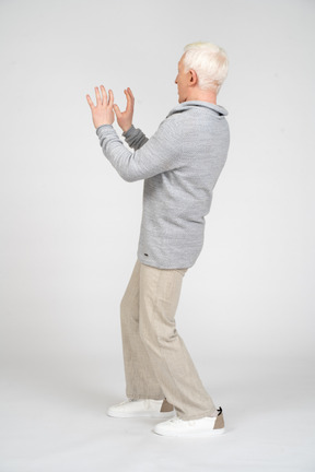 一个男人站在肘部弯曲双臂的侧视图