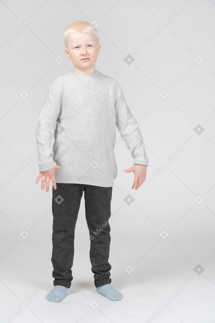 Front shot of a  displeased little boy in casual clothes  gesticulating