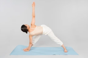 Young indian woman standing on yoga mat in a pose