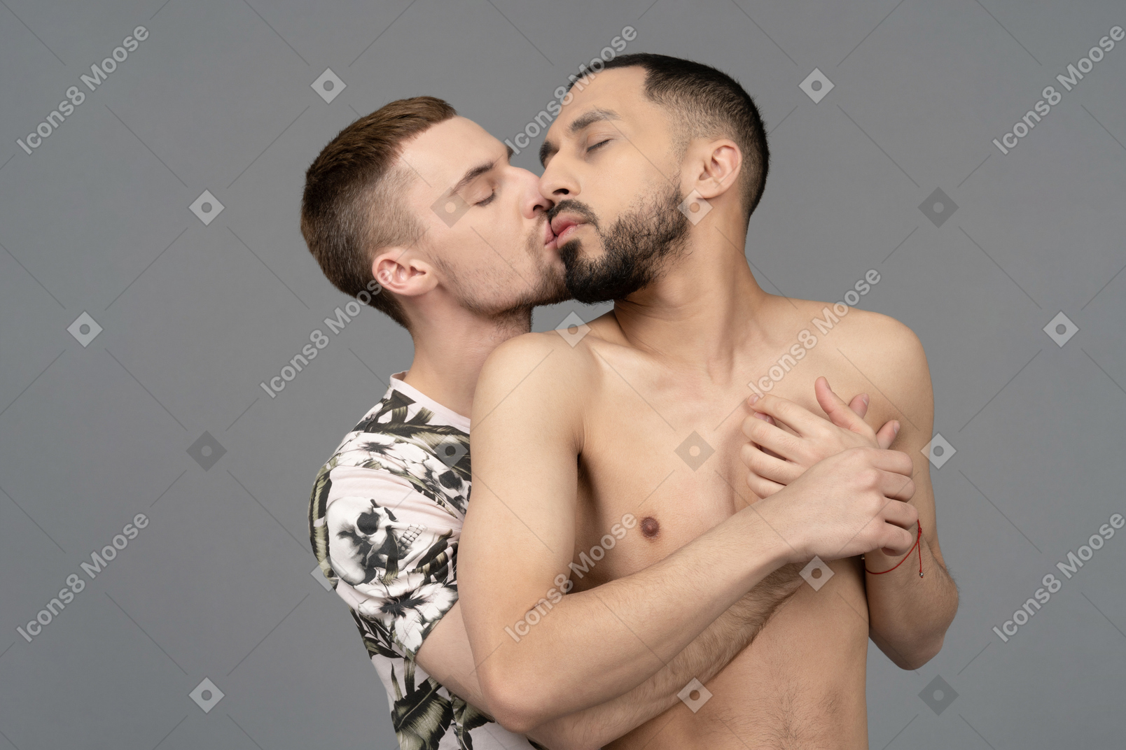 Close-up of a young man back hugging and kissing his shirtless lover