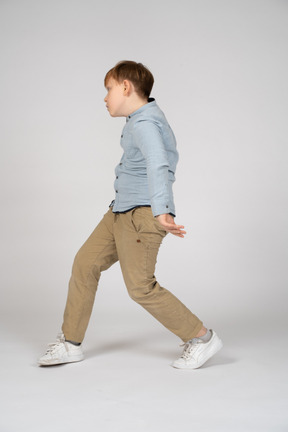 A little boy walking across a white background