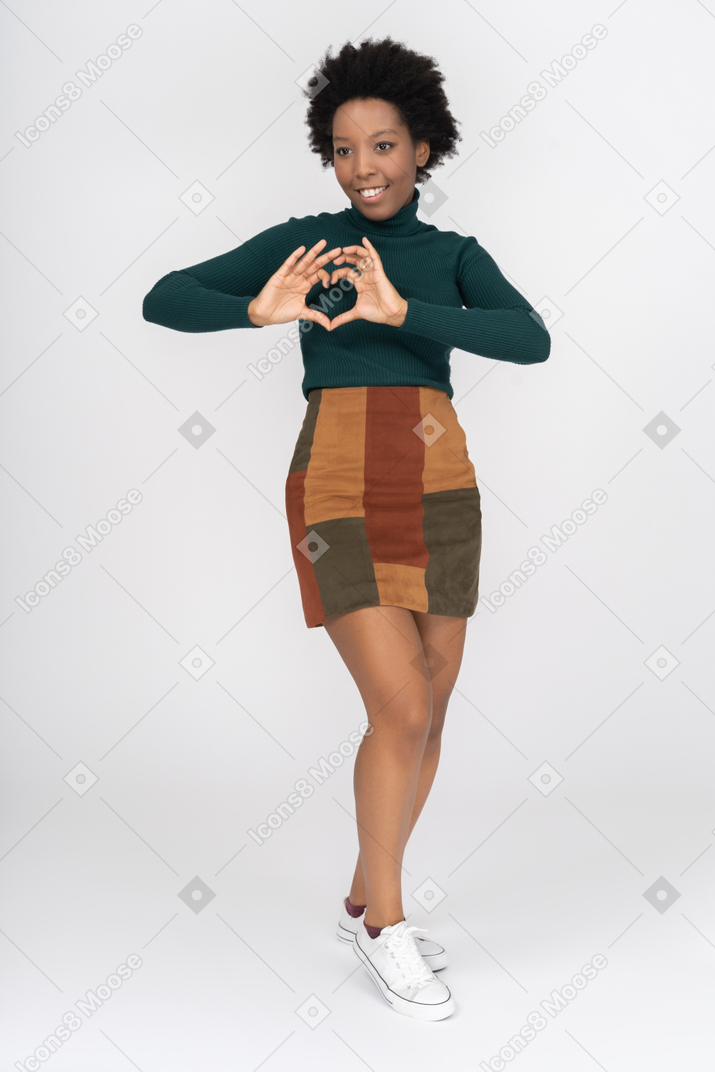 Cheerful afro girl making a heart gesture with her fingers
