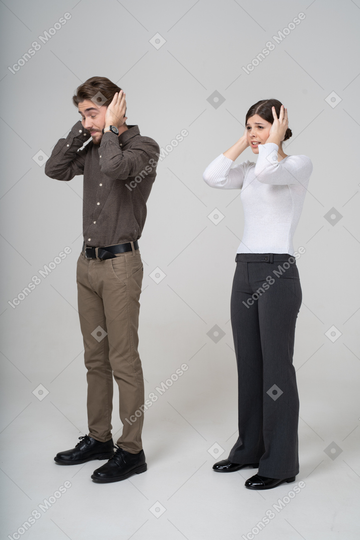 Three-quarter view of a young couple in office clothing touching head