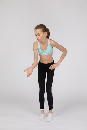 Side view of a teen girl in sportswear raising hand and arguing