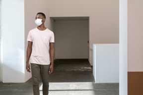 A man wearing a face mask while walking in a room