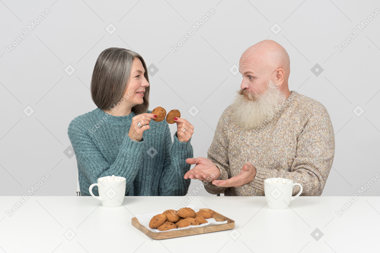 Elder woman holding cookies and her husband don't understand it