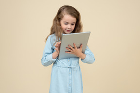 Mignonne petite fille à l'aide d'une tablette