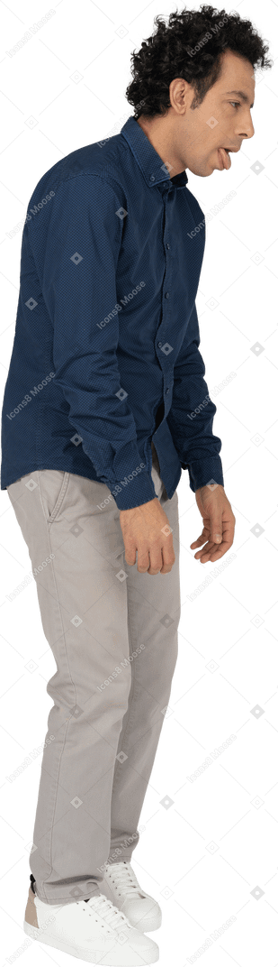 Vista laterale di un uomo in abiti casual che mostra la lingua