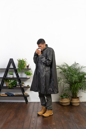 Man in raincoat drinking tea