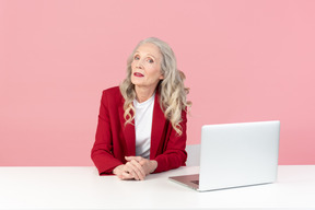 Employé de bureau féminin âgé assis devant l'ordinateur