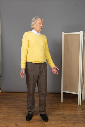 Front view of a questioning old man turning around