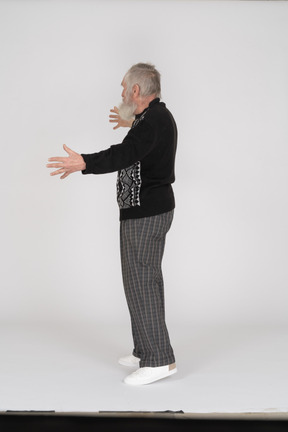 Vista lateral del anciano mostrando un gesto largo con las manos