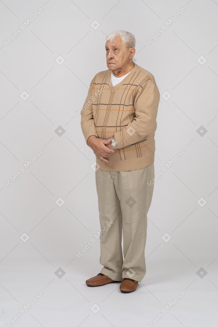 Старик в повседневной одежде стоит на месте