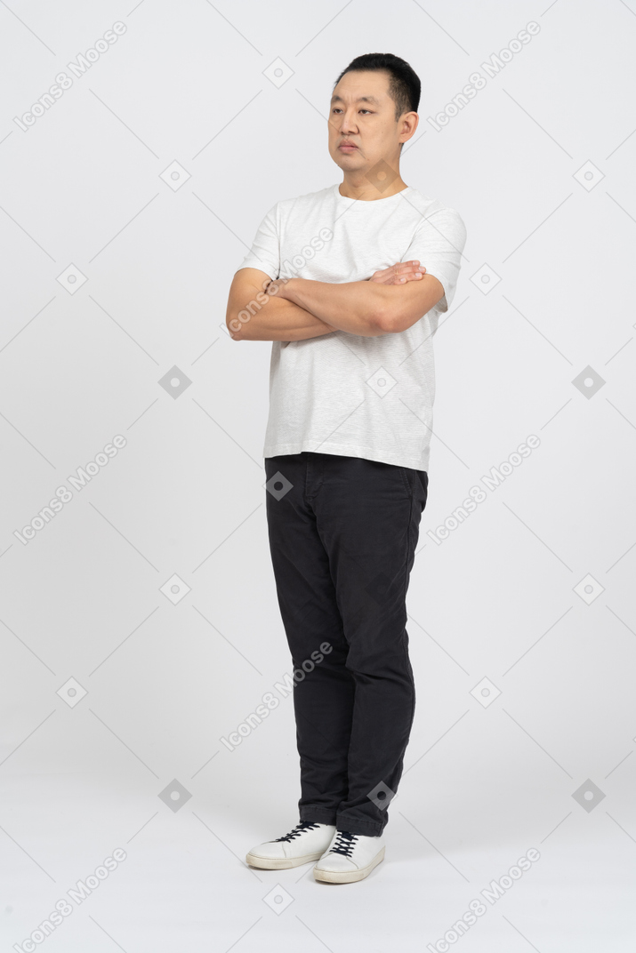 Vista frontal de um homem com roupas casuais em pé com os braços cruzados