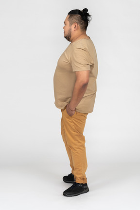 Asian man holding hands in pockets in profile