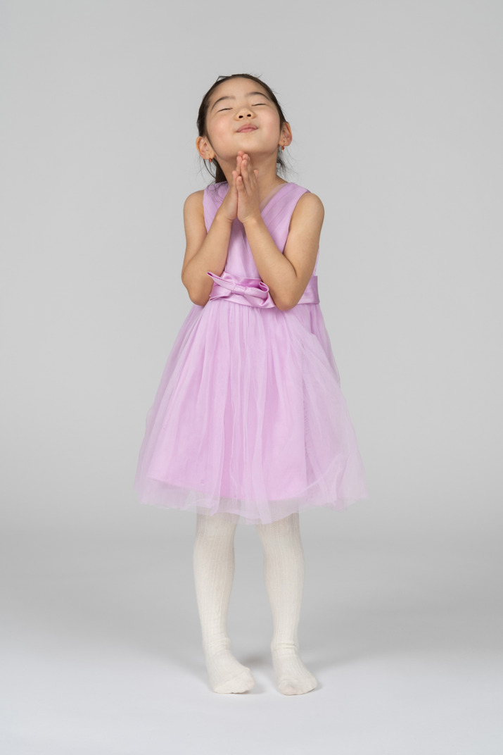 Little girl in pink dress with folded arms