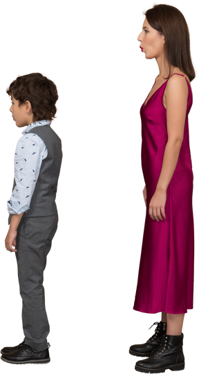 Niño y mujer en vestido rojo de pie en el perfil