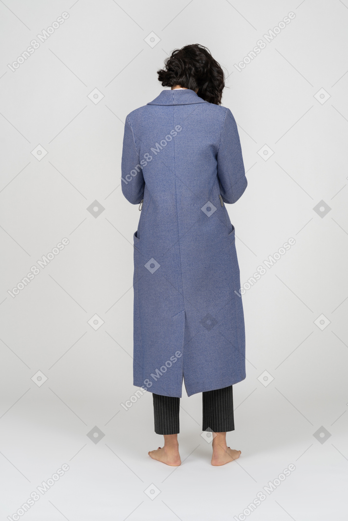 Vista posteriore di una persona in cappotto in piedi