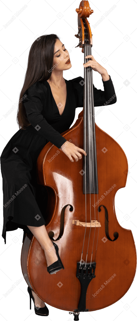 Vista frontale di una giovane donna in abito nero che suona il suo contrabbasso mettendo la gamba su di esso