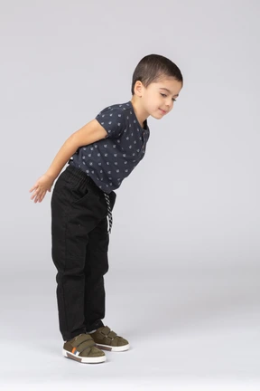 Side view of a cute boy in casual clothes bending down