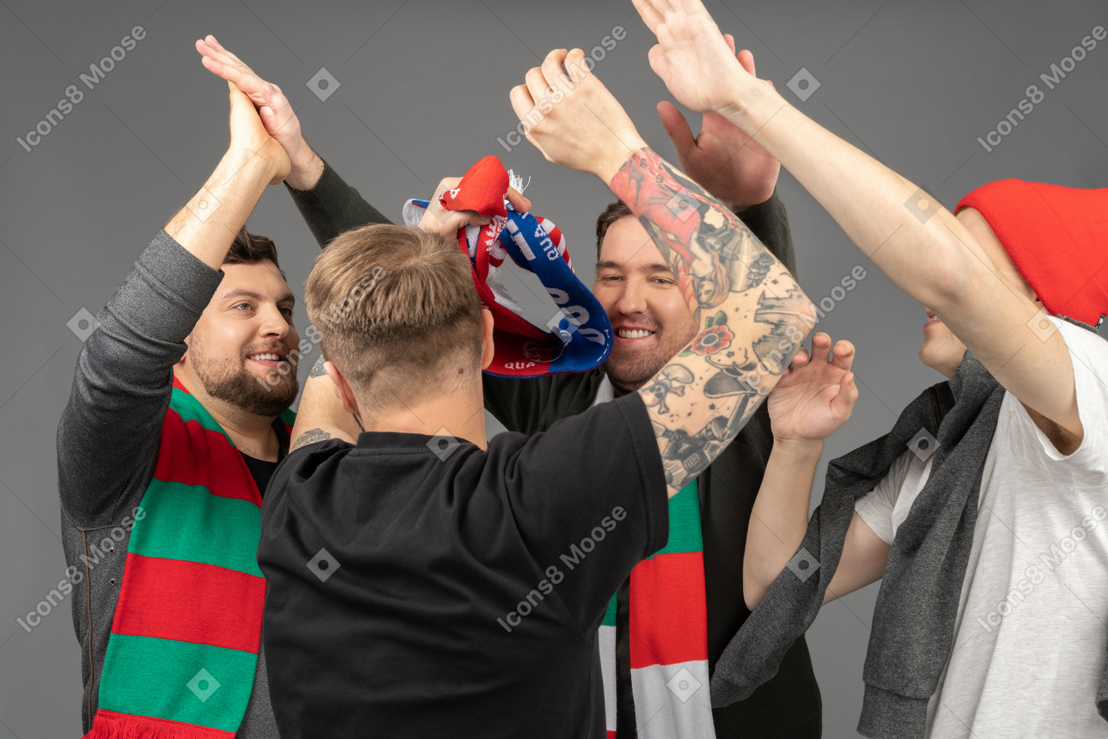 Close-up of four happy male football fans giving high five