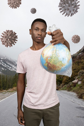A man holding a plastic bag with a globe in it