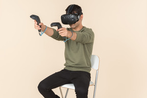 Young caucasian guy playing a virtual reality game