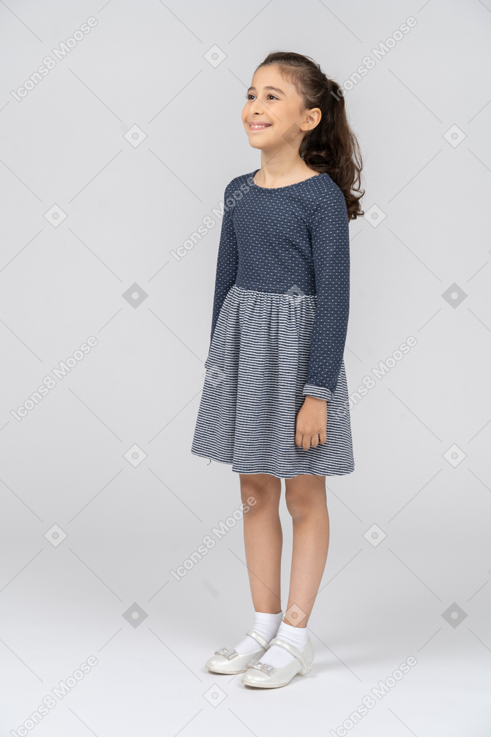 Toute la longueur d'une jeune fille souriante dans des vêtements décontractés