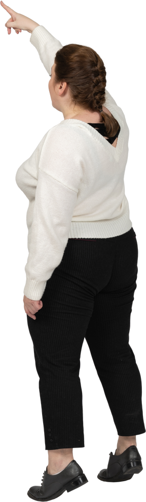 Vista posteriore di una donna plus size in abiti casual in piedi con il braccio alzato