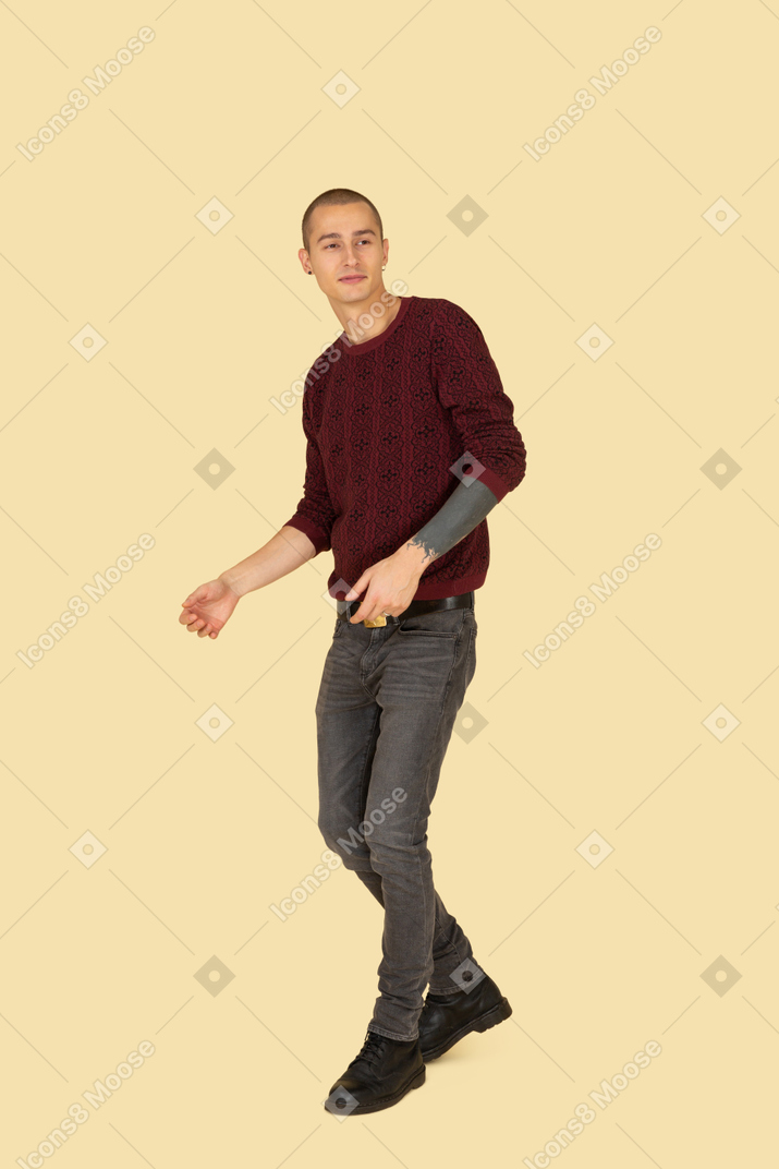 Vue de trois quarts d'un jeune homme gesticulant vêtu d'un pull rouge
