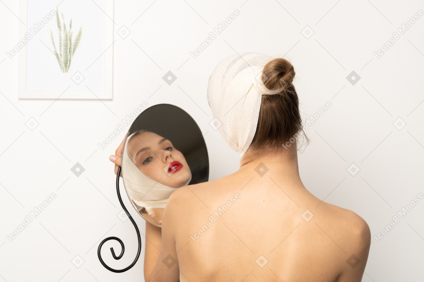 Young woman with bandaged head holding a mirror