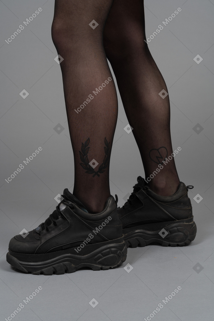 Vista laterale delle gambe in calzamaglia nera e stivali