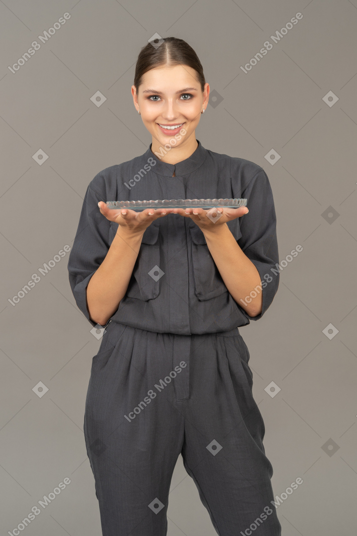 Vue de face d'une jeune femme en combinaison tenant une plaque de verre