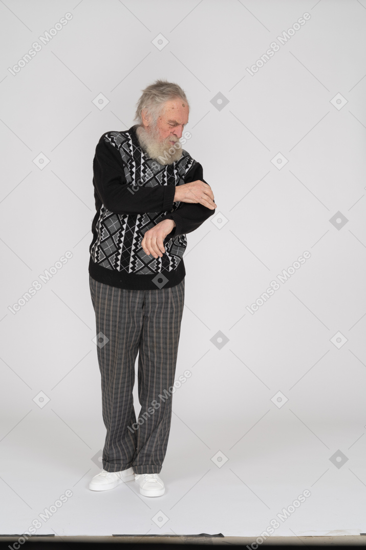 Old man removing dirt from his sweater