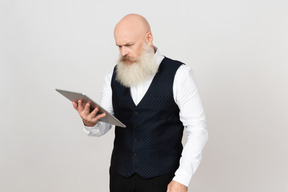 Homem envelhecido usando tablet e olhando incomodado