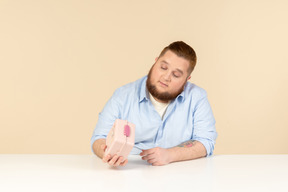 Großer mann am tisch sitzen und lunchbox halten