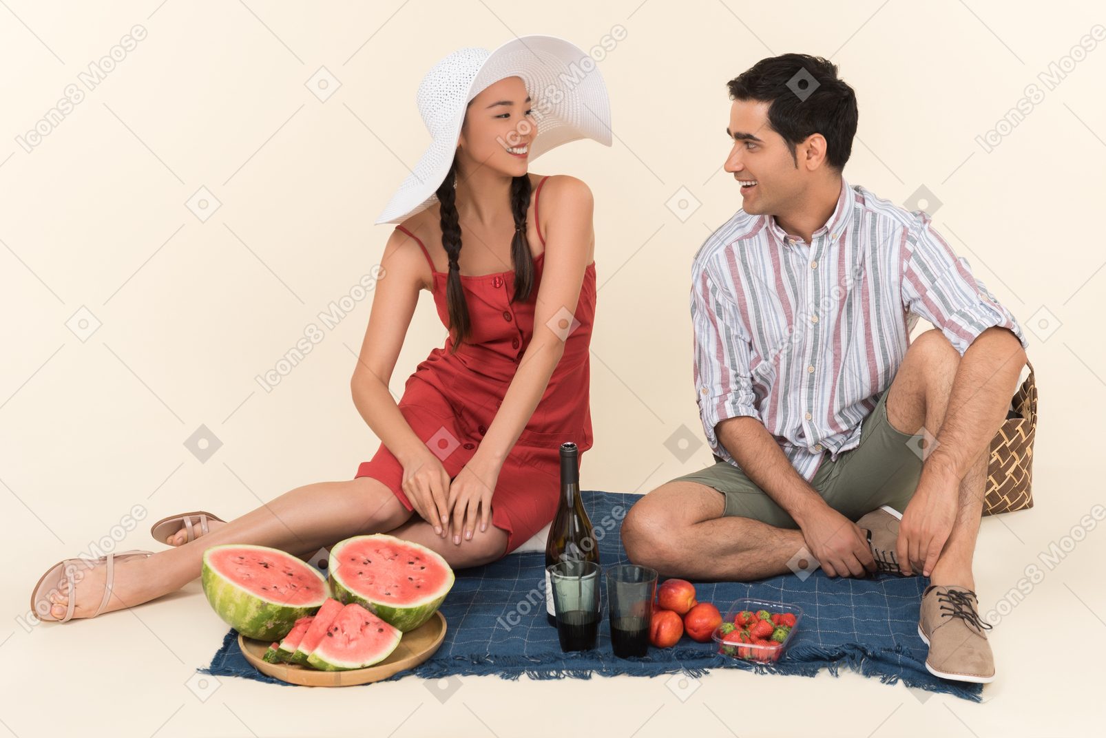 Young interracial couple talking while having picnic