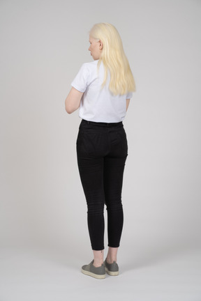 Three-quarter back view of a young woman in casual clothes