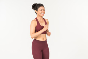 Niña india sonriente en ropa deportiva para correr