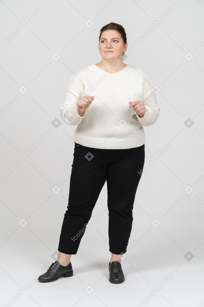 Mulher plus size com suéter branco posando