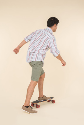 Young caucasian guy standing on skate