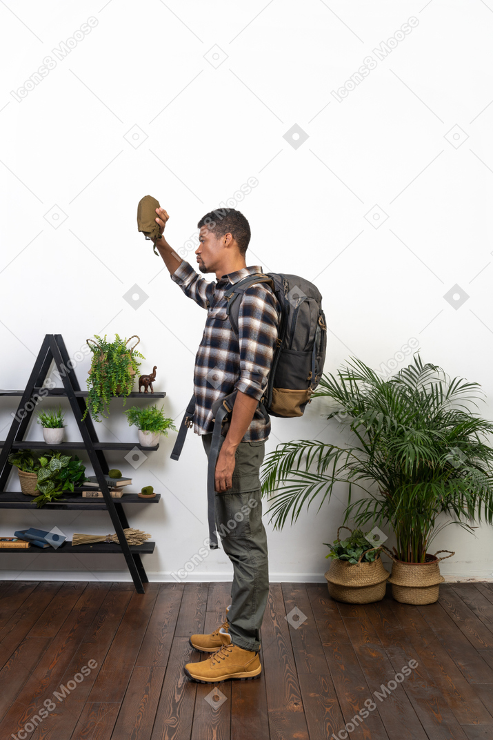 Side view of a backpacker holding up an empty flask