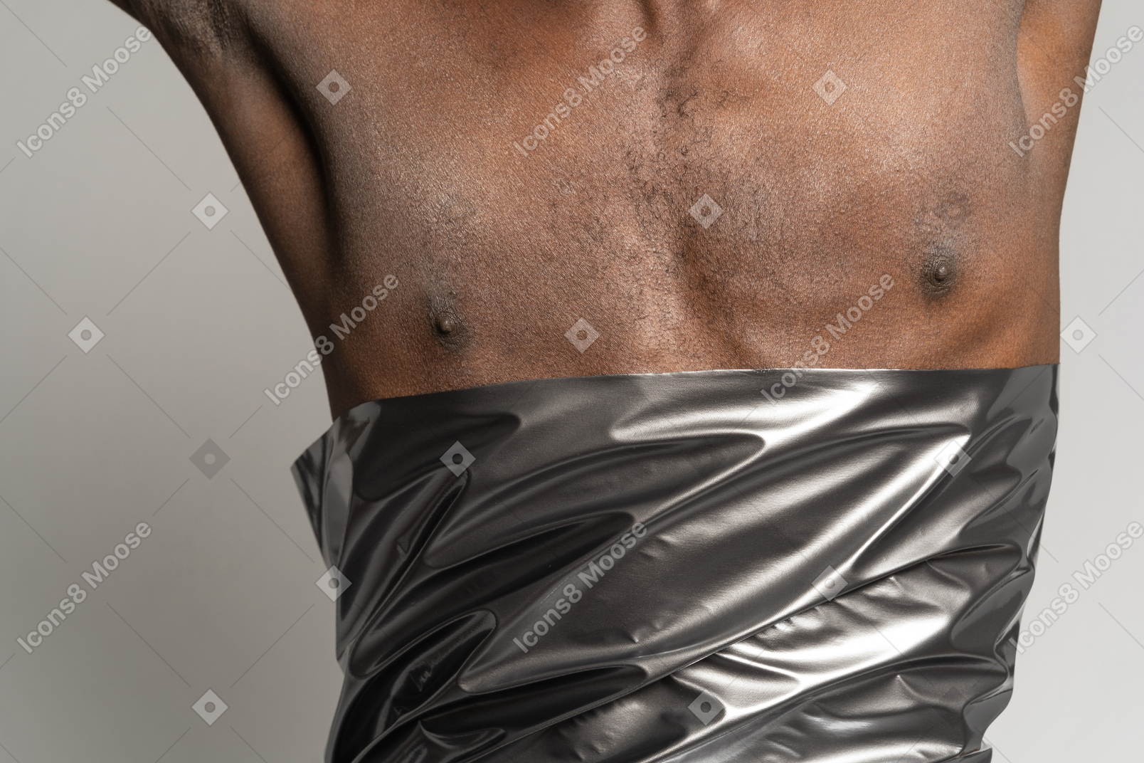 Primer plano del torso de un hombre envuelto en satén plateado